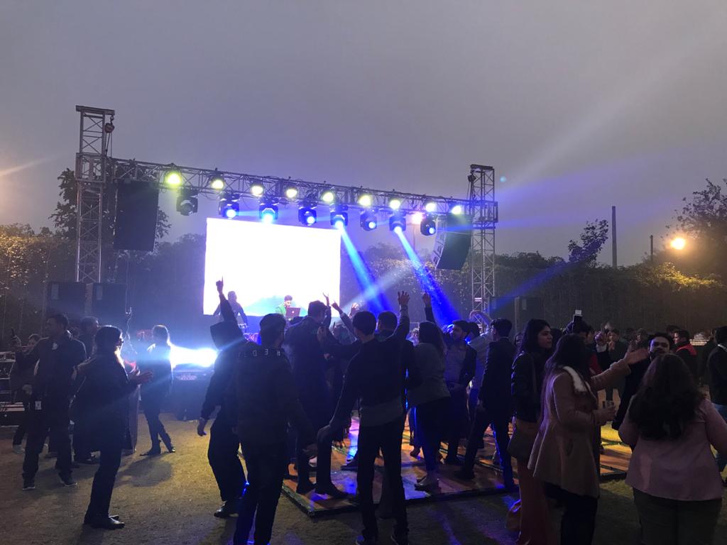 Stage lighting and a screen over a crowd