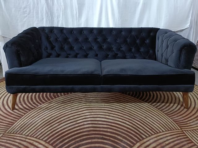 Navy chesterfield sofa on a patterned rug